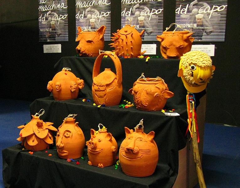 pignatte_fondazione.jpg - Dieci delle venti pignatte modellate dagli artisti attendono la loro sorte di fronte al pubblico che sta per incontrare Paolini. Il bastone che le distruggerà sorregge il casco zoomorfo.